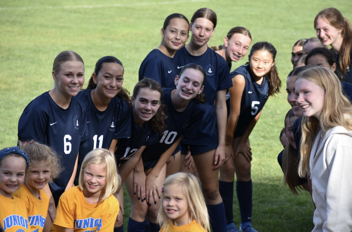 TOGETHER AS ONE. The Junior Spartans join the Girls Varsity Soccer team on the field for announcing the team line-up.
